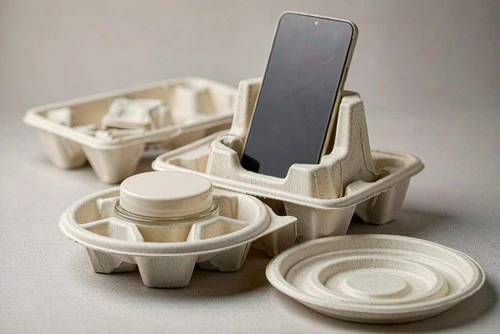 Molded pulp and molded fiber packaging trays holding a cosmetic jar and a smartphone